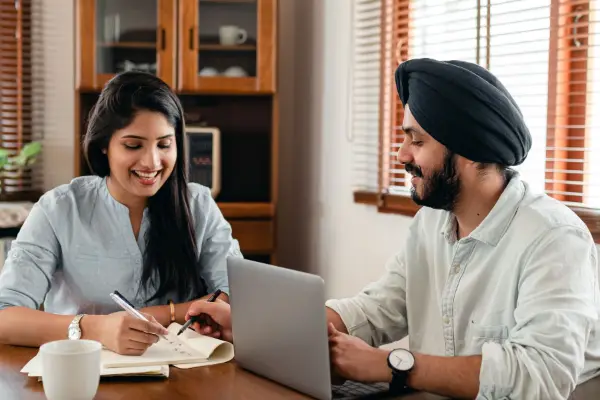 Two learners studying together at home on a laptop